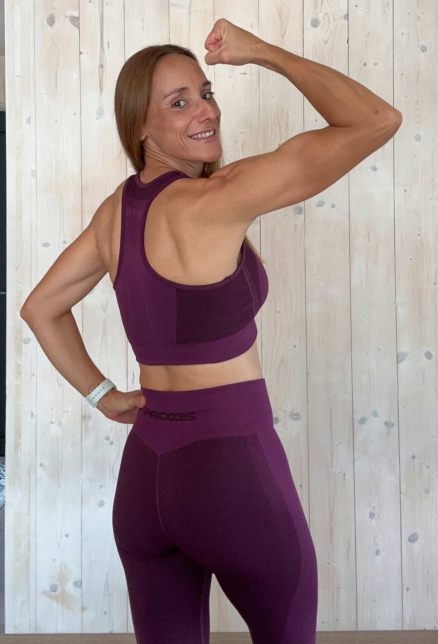 La entrenadora se está estirando en una pista de carreras.